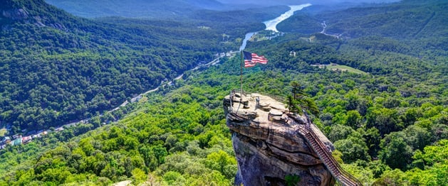 Chimney Rock in Western North Carolina overlooks a wide valley of green and twisting rivers.