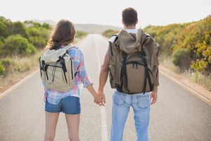 A hiking young couple standing on countryside road
