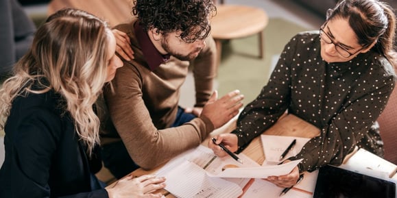 A couple works with a financial advisor to figure out home mortgage rates.