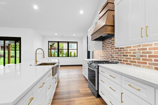 white kitchen with brick backsplash