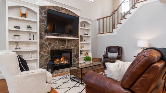 a home is furnished with a fireplace and proper shelving to hold fun items