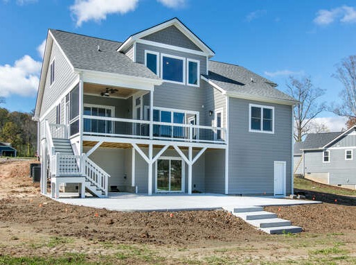 A one-story blue house with white trim and lawn of lush green grass is vibrant under the bright sunlight. The driveway to the garage and sidewalk to the front door are bright and clean.