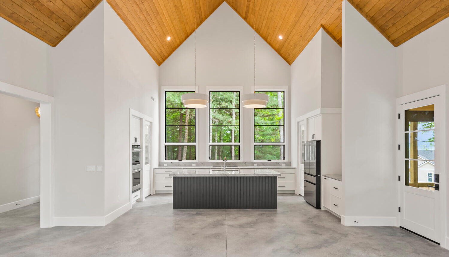 A beautiful interior of a home with granite floors, and bright wooden accents on the ceiling.