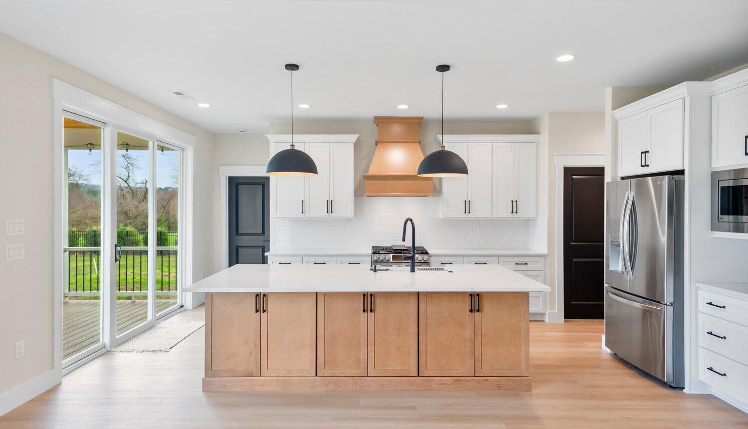 A home with a clean aesthetic and open floor plan design with wooden cabinetry and wooden floors.